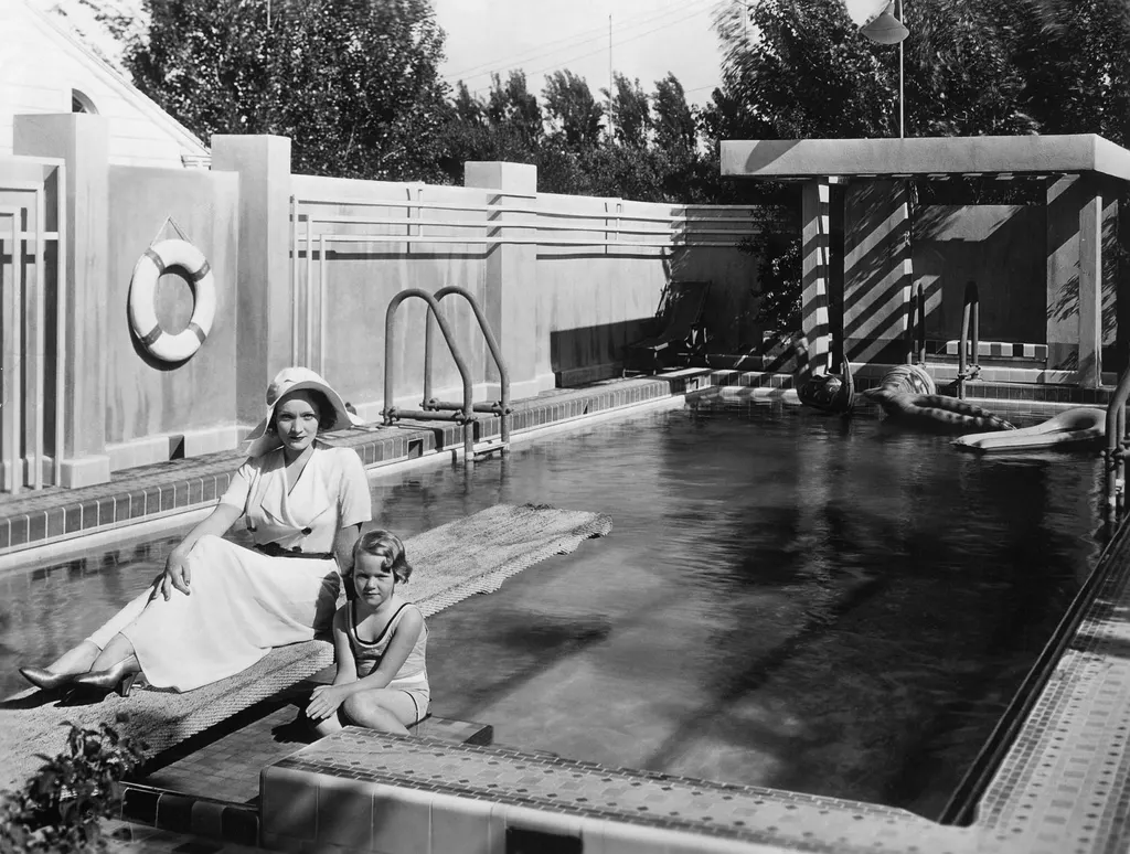 blackandwhite image of Marlene Dietrich and daughter young daughter Maria poolside at home