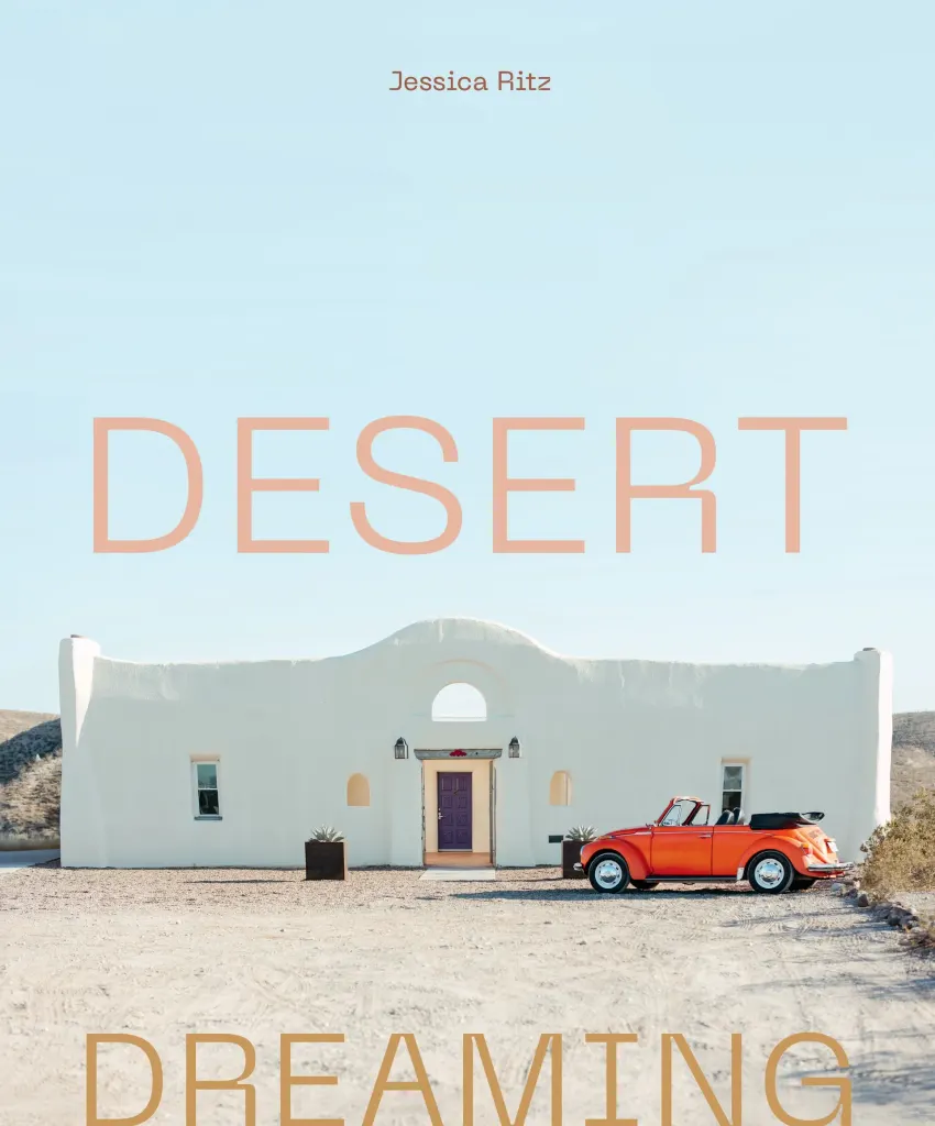 Desert Dreaming book cover showing white building against desert soil and clear blue skies