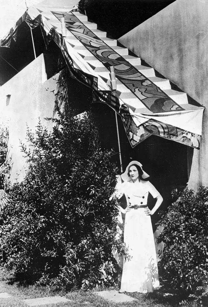 blackandwhite photo of Marlene Dietrich standing outside hollywood home