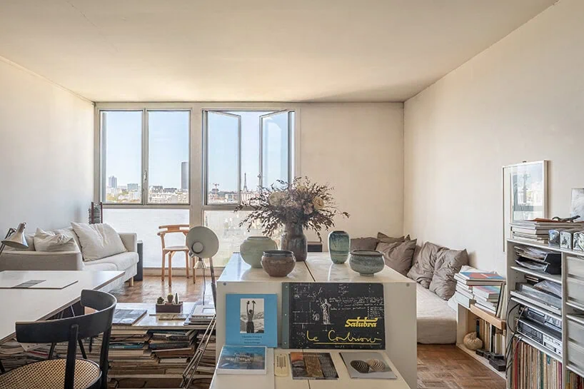 the living room opens toward the Paris skyline through a series of large windows