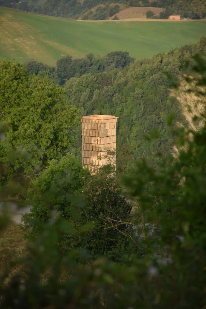 between a bell tower and a military tower, a wooden tower with a shifting facade appears