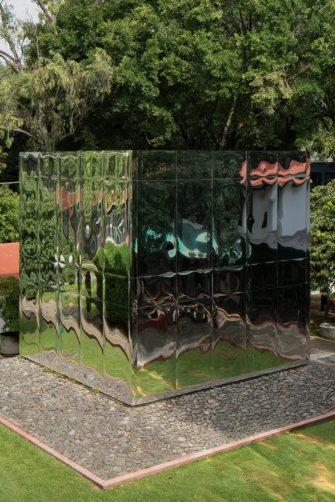 reflective surfaces blur the distinction between the built object and its natural surroundings