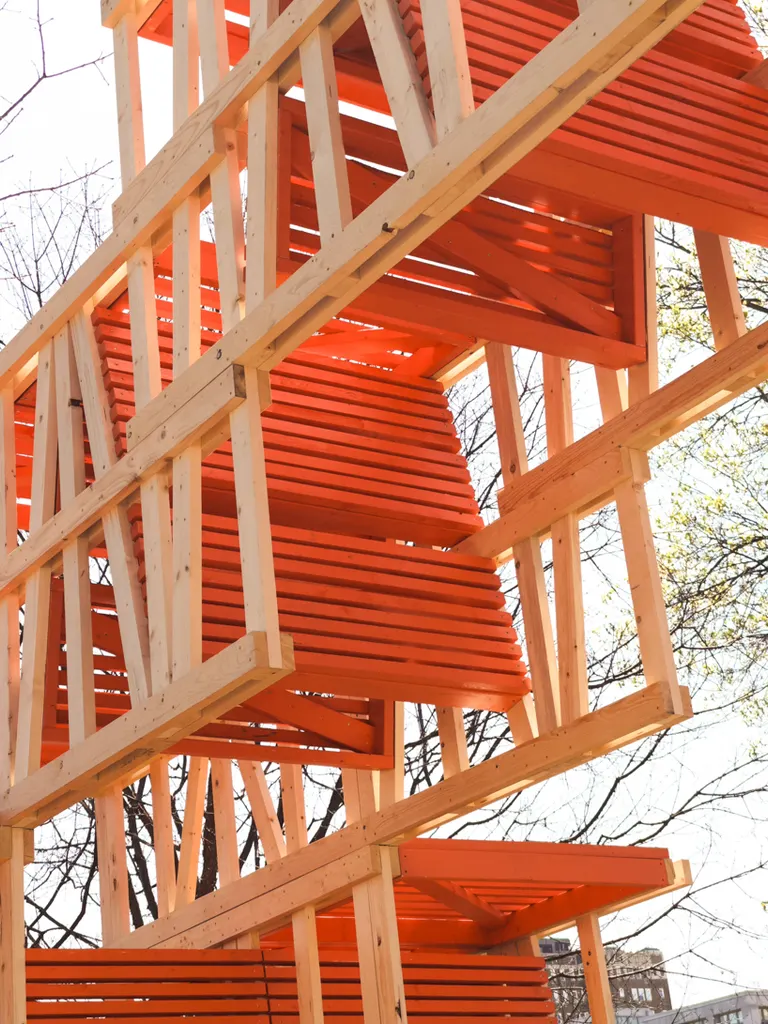 brightly painted orange infill panels connect the timber frames