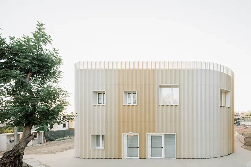 curved corner margins soften the building’s geometric silhouette against the streetscape