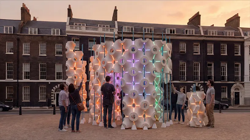 as visitors gather, changing colors register their presence across the modular surface