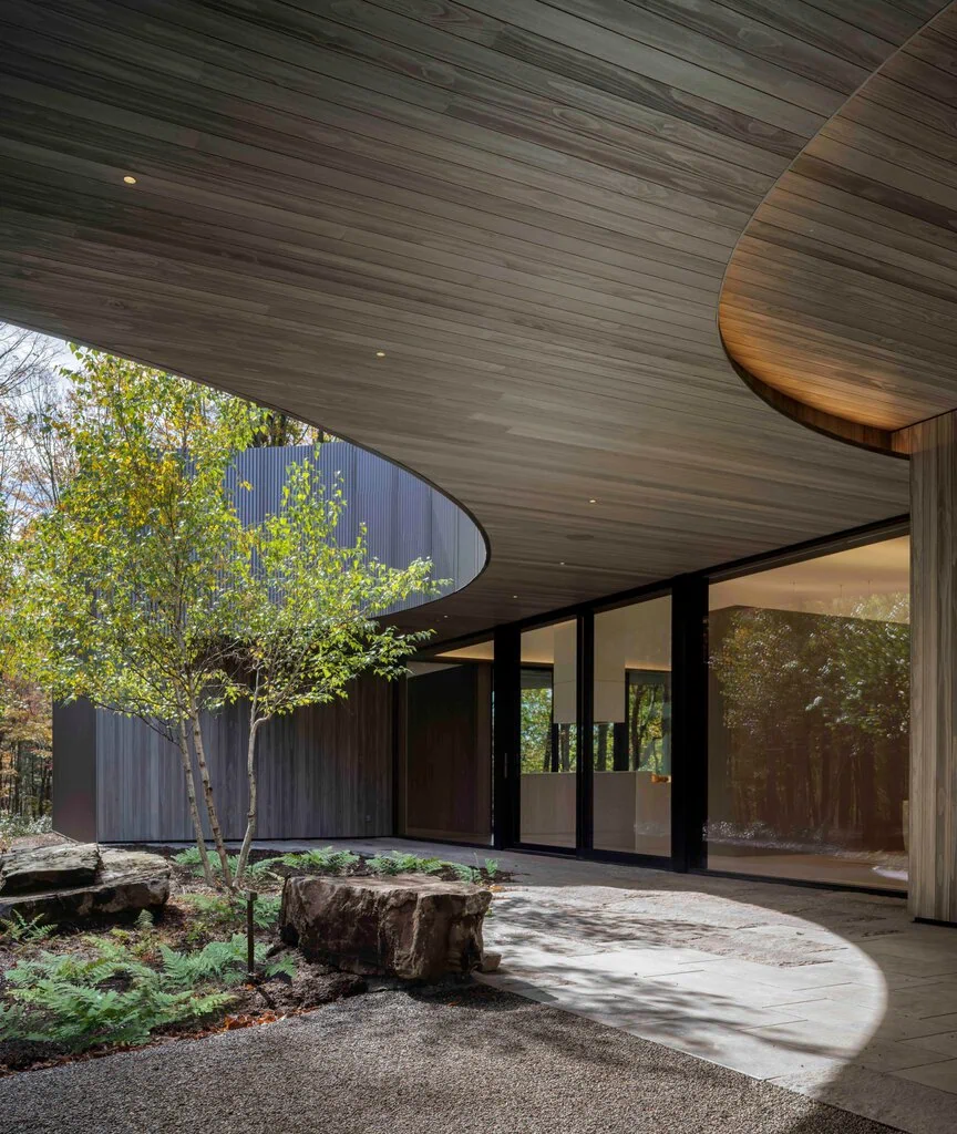 Corrugated metal and accoya wood line the exterior of the home