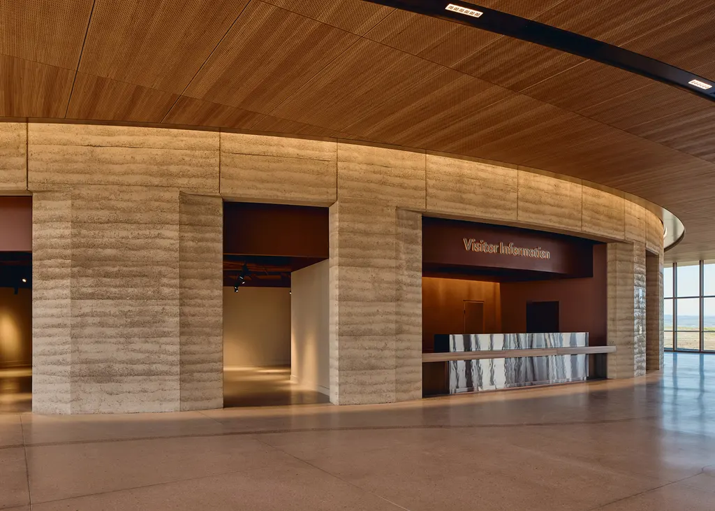 The material palette includes rammed earth and plywood