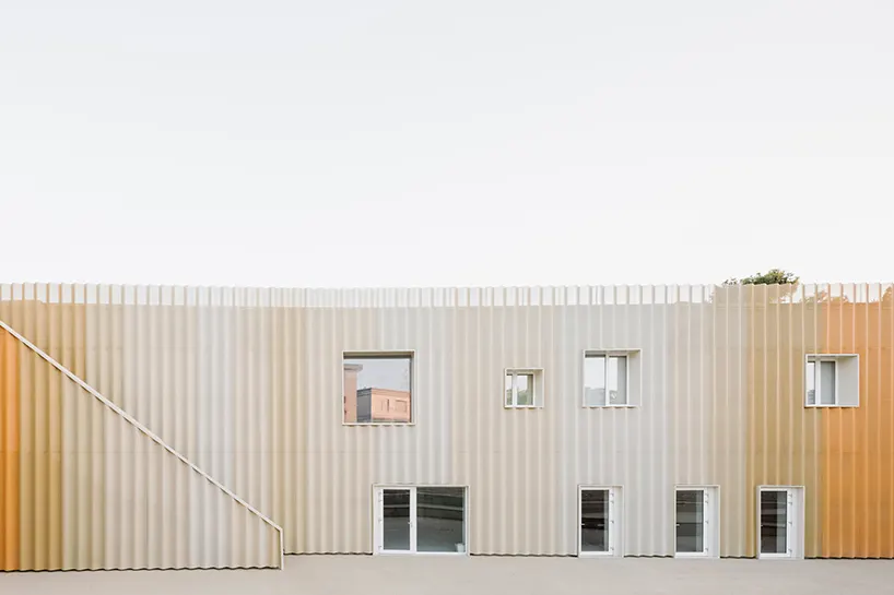 the textured metal facade responds to natural light, shifting visual appearance throughout the day