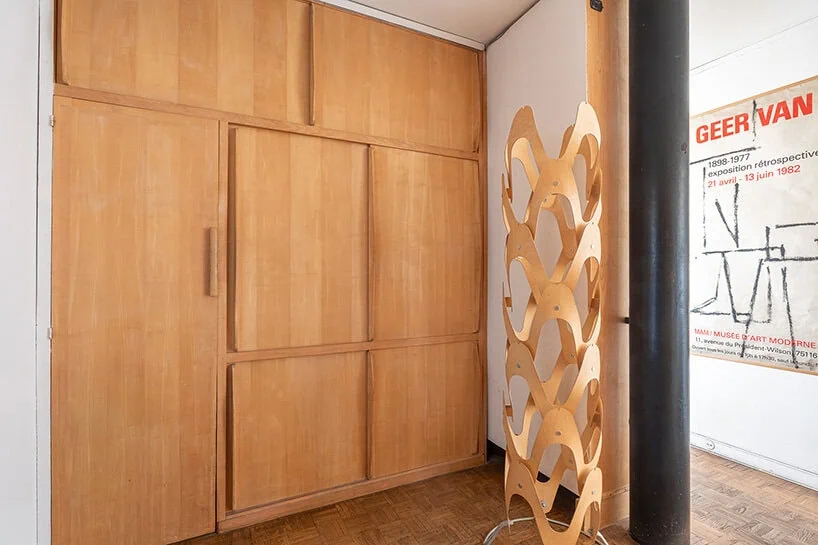 built-in wooden storage attributed to Charlotte Perriand lines the entrance
