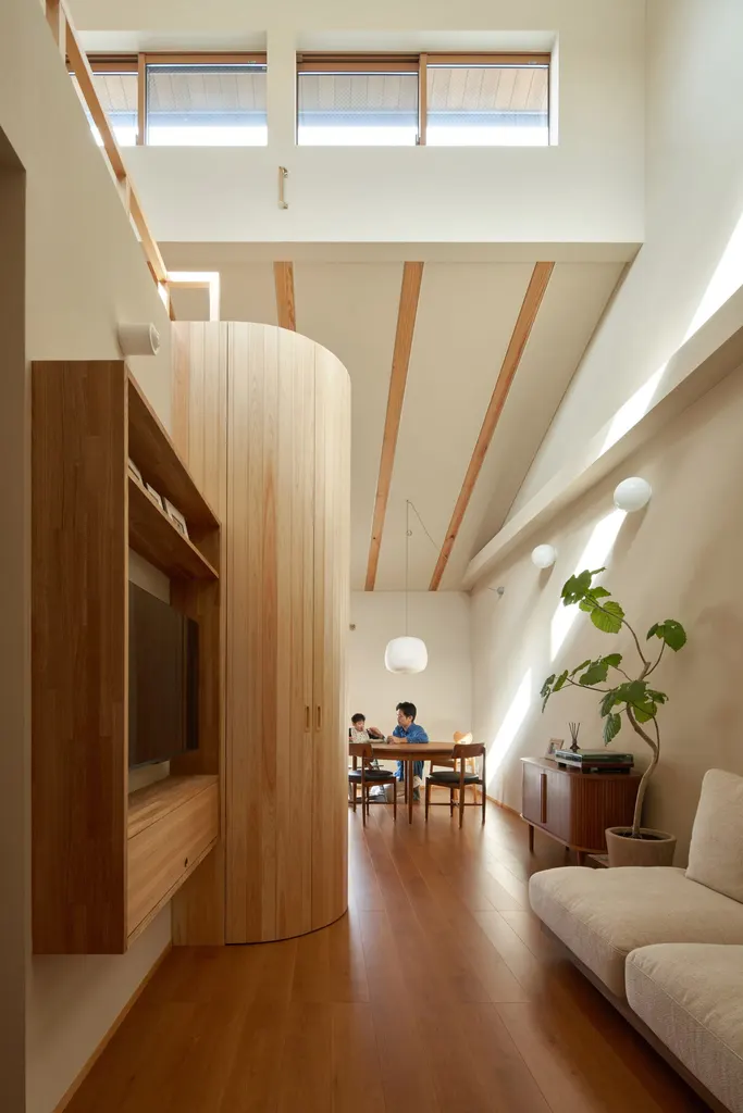 A curved timber wall helps separate the living room from the dining and kitchen area