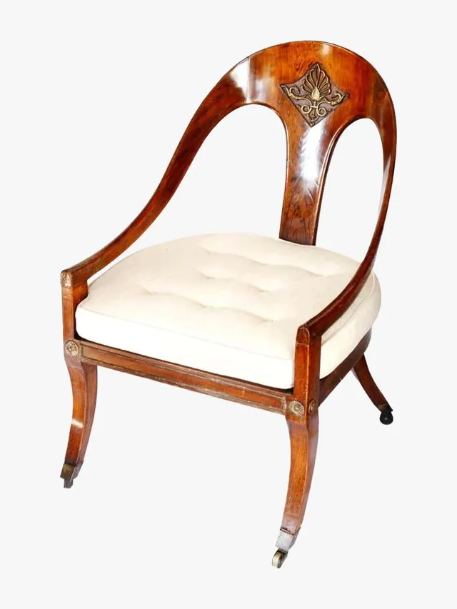 Armchair with spoon shaped back and brass inset detail.