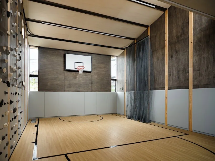 the large free space accommodates a range of family activities, including basketball, judo, golf, and bouldering