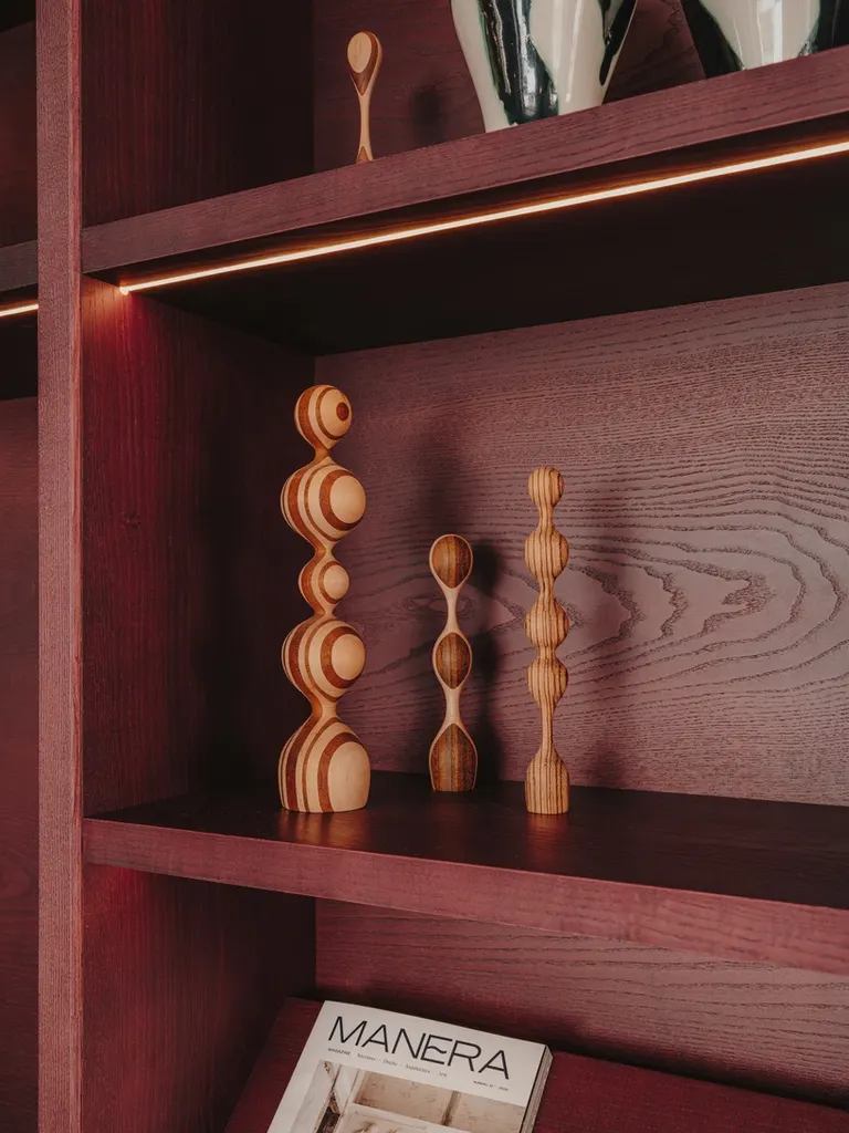 custom shelving combines books, objects and integrated warm lighting to create an intimate, domestic atmosphere