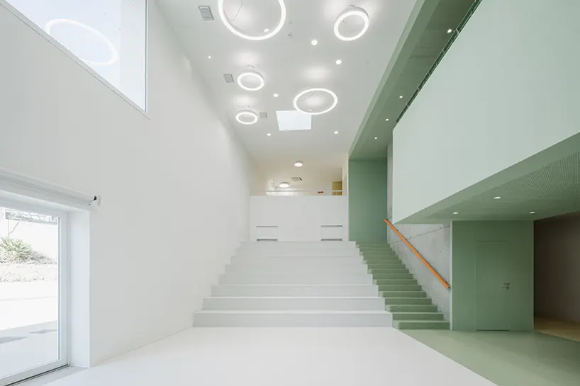built-in stepped seating (koilon) converts the central hall into a informal gathering space