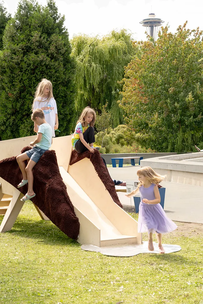 children sitting on the ridge of Slide Horse and sliding down