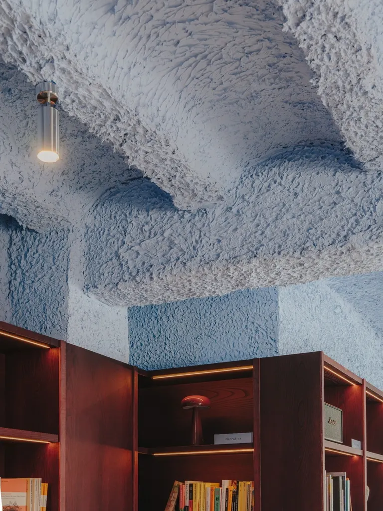 the textured blue ceiling preserves and highlights the existing architectural character of the interior