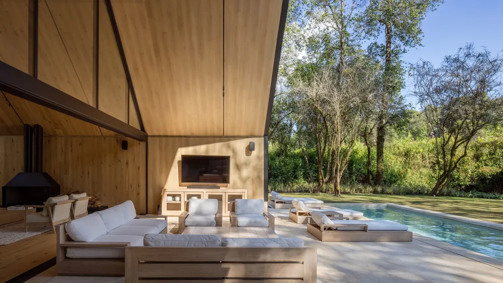 A patio space is surrounded by olive trees